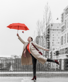 woman standing on one leg holding an umbrella